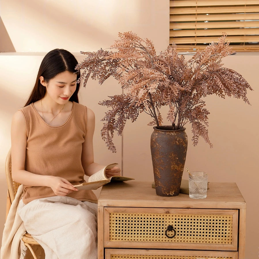 Coffee beige faux fern branch styled in a rustic vase for living room decor and natural interior styling
