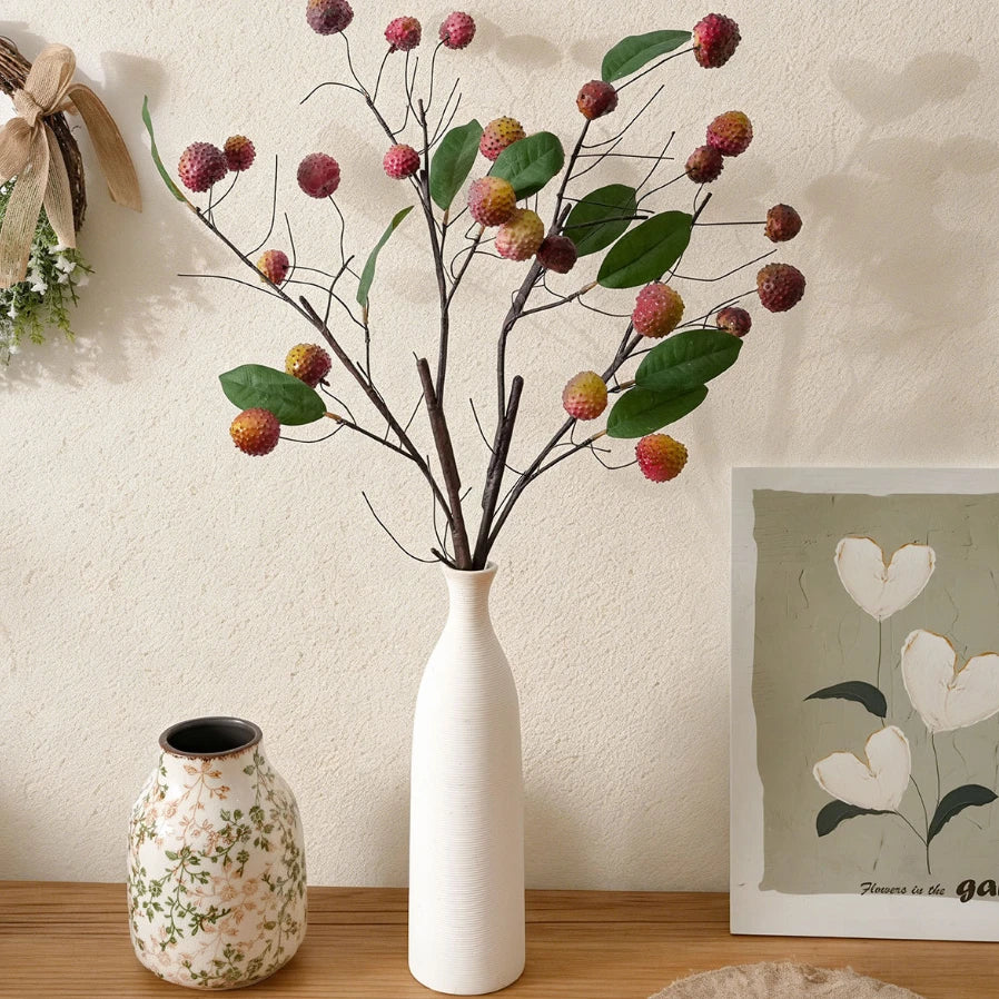 Lifelike faux lychee stems in a white vase for rustic shelf and mantel decoration