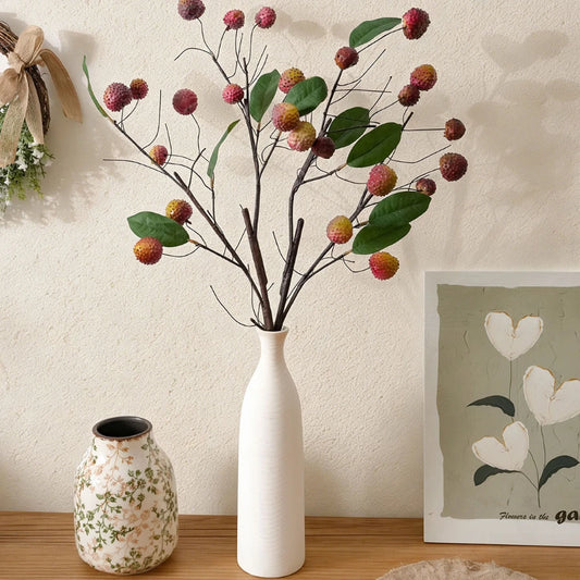 Lifelike faux lychee stems in a white vase for rustic shelf and mantel decoration