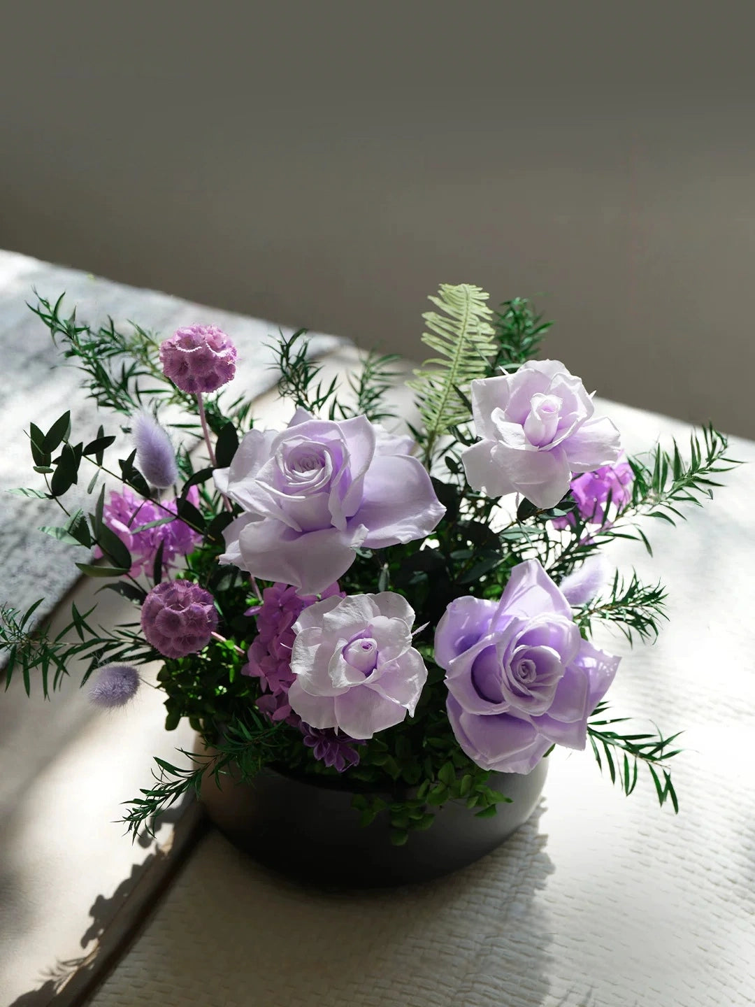 Lavender purple preserved rose bouquet, stylish tabletop decor with natural light