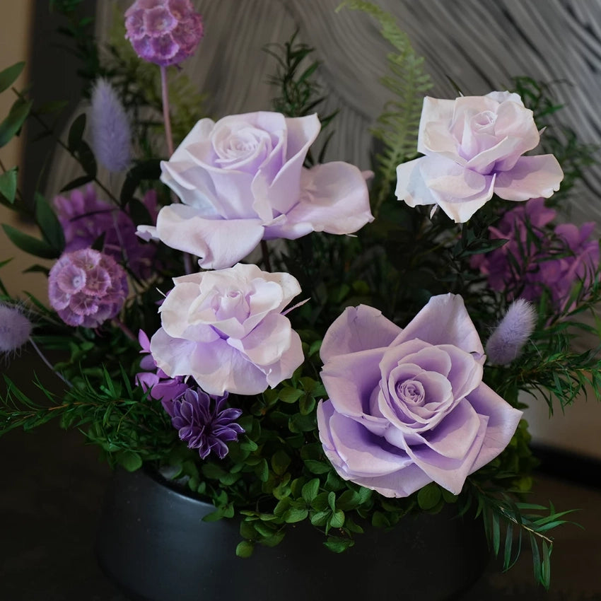 Purple preserved rose arrangement with lush greenery, artistic home decoration