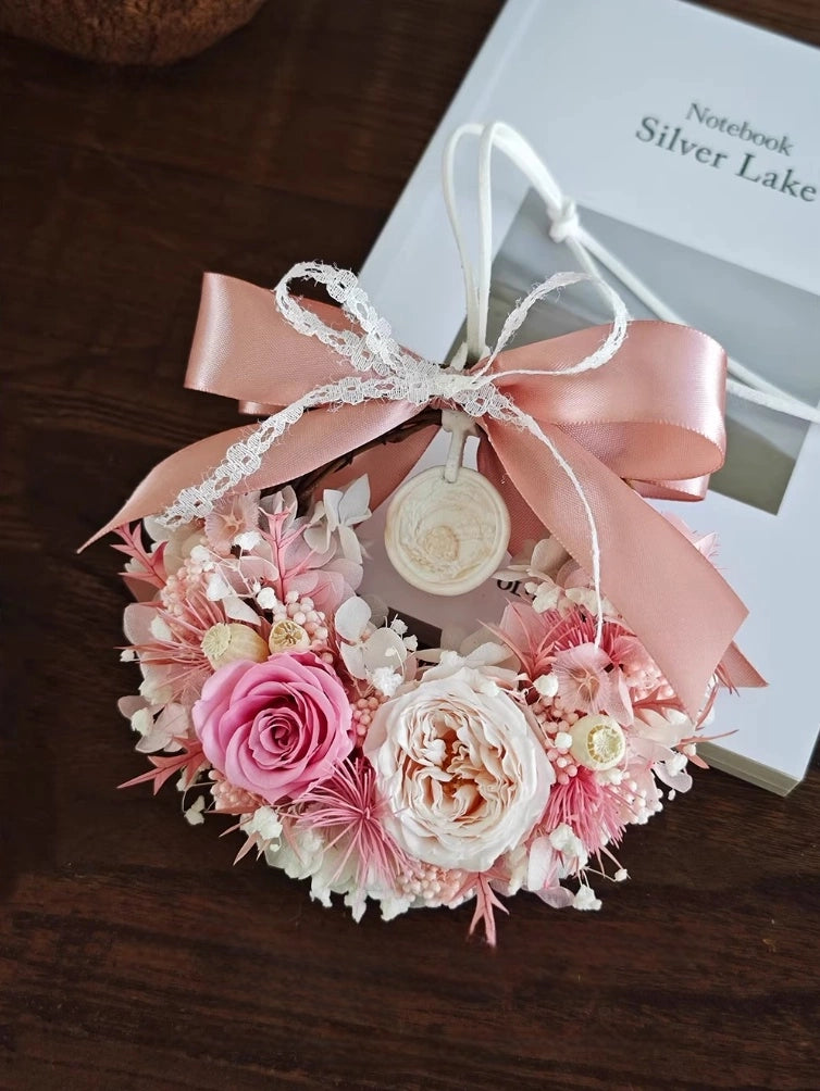 Pink preserved flower wreath with roses and lace ribbon for elegant wall decoration