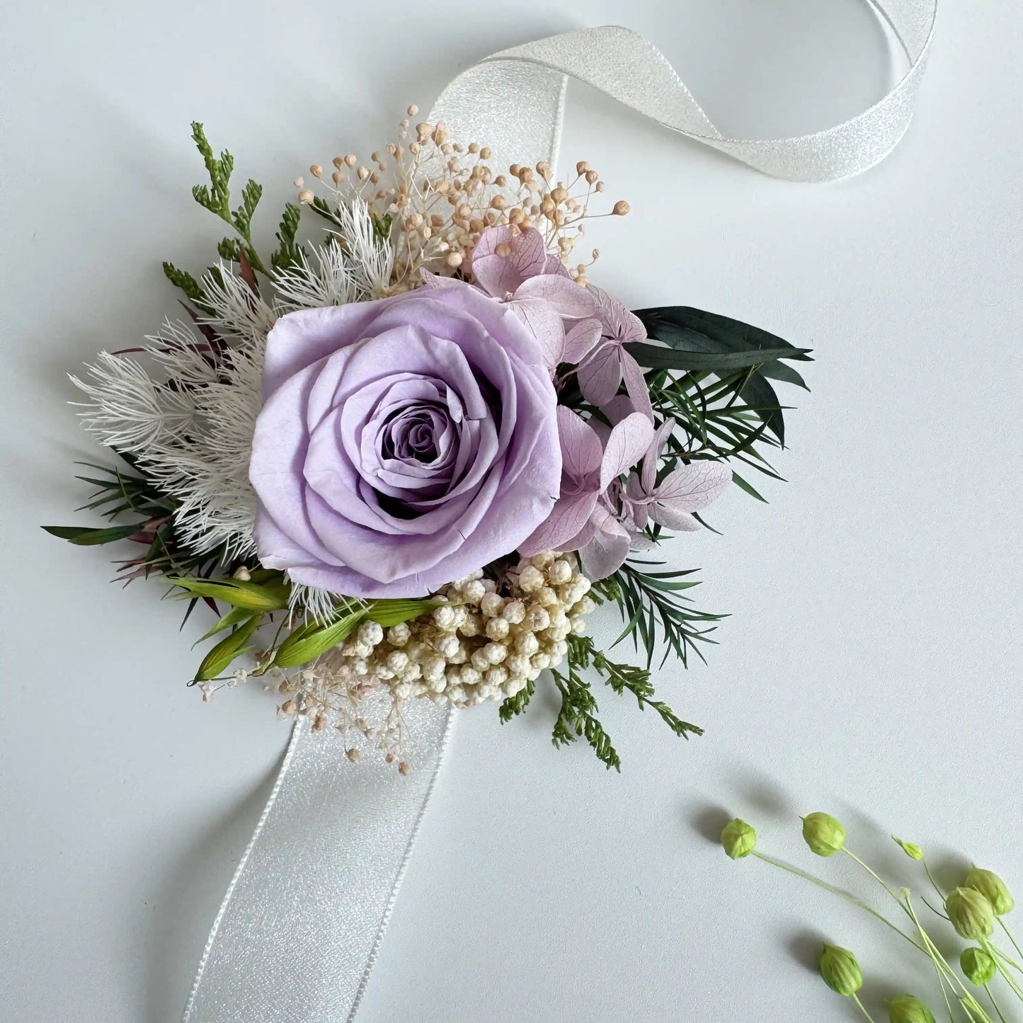 Lavender rose wrist corsage with preserved flowers and white ribbon for bride
