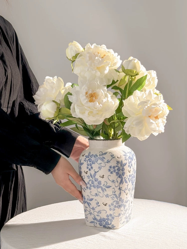 Realistic white peony faux flowers styled in ceramic vase for room decor